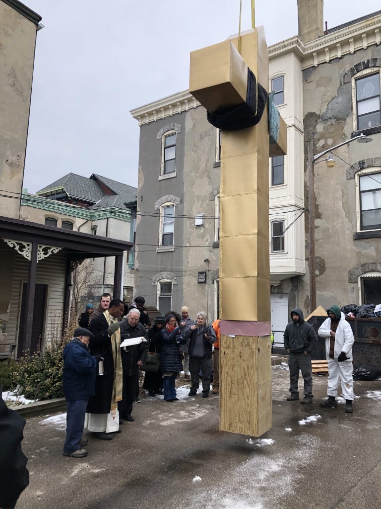 Fr. Joseph prays a blessing over the new cross at St. Vincent's