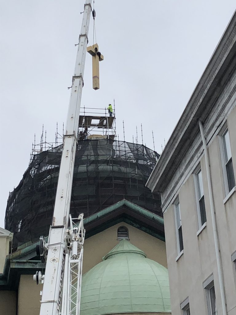 Crane lifts cross to top of St. Vincent's dome